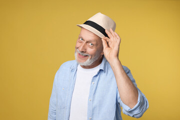 Portrait of happy senior man on yellow background