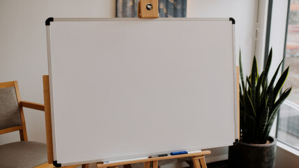 A blank whiteboard on an easel in a well lit room