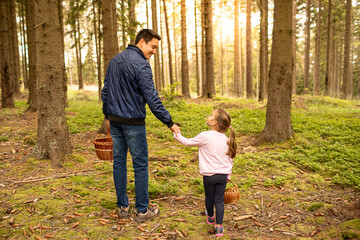 Fototapeta premium Father child walking in the forest going blueberry mushroom picking, family outdoor activities, dad daughter bonding 