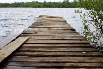 Obraz premium Wooden bridge near the lake shore. 