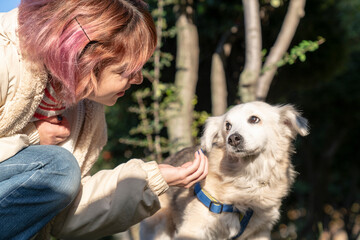 Young woman lovingly caresses her dog