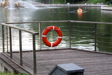 Obraz premium There is a lifebuoy hanging on the fence at the pier near the reservoir. 