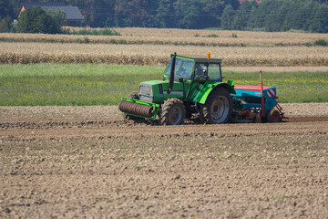 Farmer in tractor seeding soybeans at industrial agricultural farm 