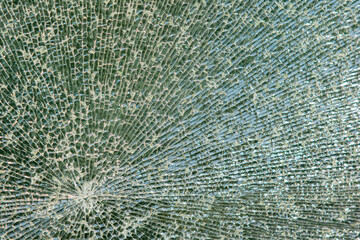 cracked glass, taken out outside of a residential building, texture of broken glass on a blue background. The surface is cracked. Broken. Holes after bullets. background with broken glass