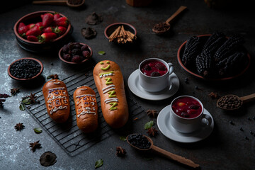 Guaguas de Pan with cups of Colada Morada, traditional Ecuadorian food for the day of the dead, surrounded by the ingredients to cook the colada