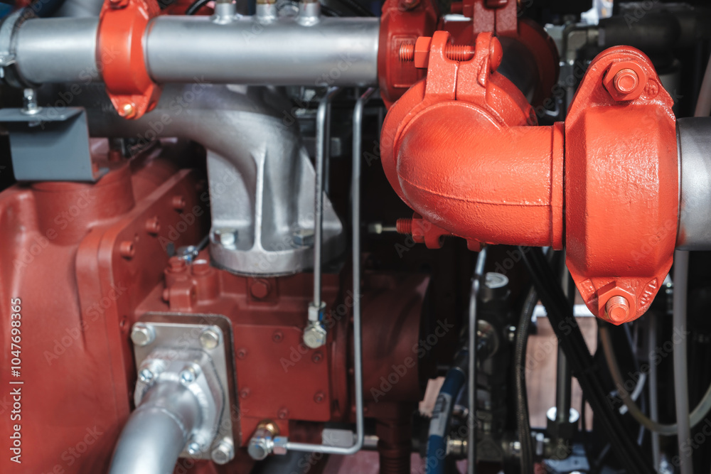 Poster a red pipe with a silver cap is attached to a red pipe. the pipes are connected to a industrial mach
