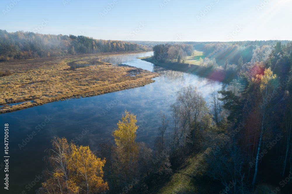 Poster a river with trees on both sides and a foggy mist in the air. the mist is creating a serene and peac