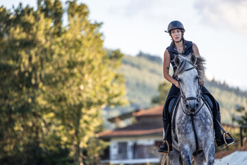 copyspace young woman rider gallops towards the camera while training with her horse at the ranch