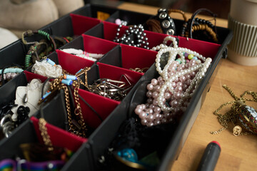 Pearl beads or necklace in container with other secondhand accessories such as earrings, bracelets, chains and hair clips
