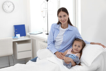 Obraz premium Mother and her little daughter on bed in hospital
