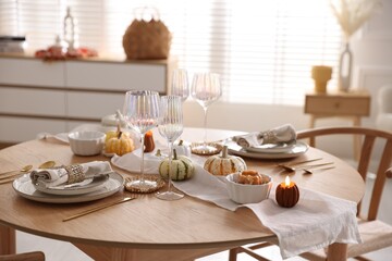 Stylish table setting with beautiful dishware and autumn decor in dining room