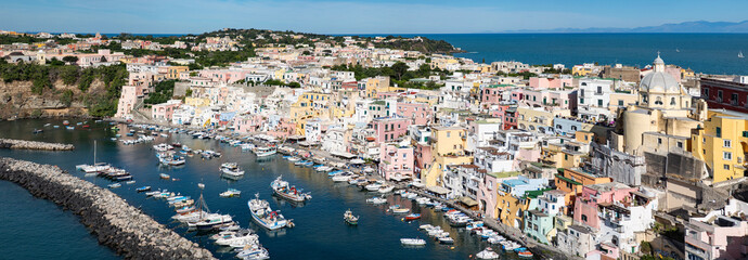 Naklejka premium panoramic view of Coricella town, sea and castle on beautiful Procida island with colorful houses in sunny summer day Italy