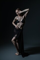Artistic expression of a tattooed model posing dramatically in low light