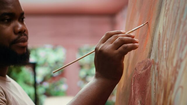 Painter uses a variety of brushes and paint tubes to create masterpiece for the fine art gallery exhibition, creative atelier. Working on colorful artwork with creativity and dedication. Camera A.