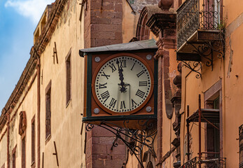 An old historic wall clock on the facade of a church in the old town centre of Bosa, Sardinia