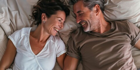 Mature couple enjoying quality time on a bed in their stylish apartment. They are happily bonding and conversing during a romantic getaway