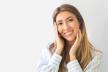 Portrait of a young Caucasian woman with pleasant smile isolated on yellow wall with copy space. 
