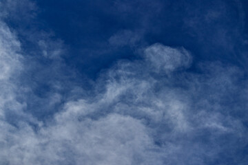 Veil of thin clouds floating under a cobalt blue sky.