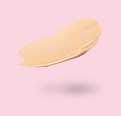 Skin foundation in air on pink background. Cosmetic product