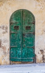 An old wooden blue door in a Mediterranean setting in a historic town in Italy.