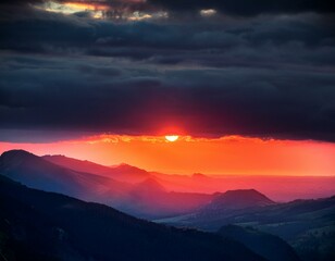 Obraz premium the red sunset shines through between the mountains and dark clouds
