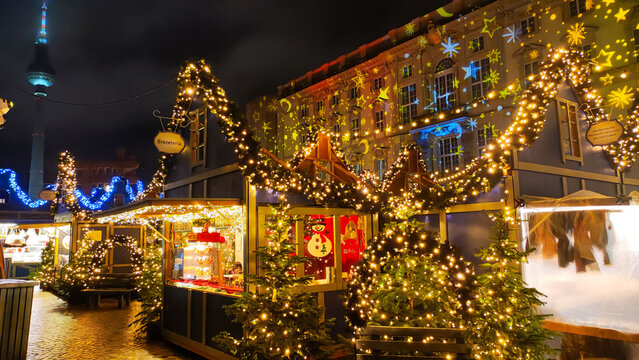 Christmas market at Humboldt Forum in Berlin, Germany, adorned with dazzling lights and festive decorations, creating a joyful holiday atmosphere during the evening