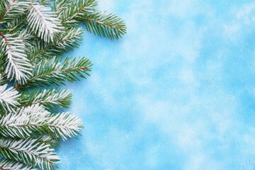Obraz premium Snow-dusted pine branches on a textured blue background. A winter-themed image perfect for banners, posters, or seasonal advertisements.