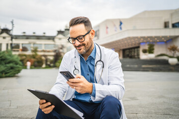 Adult man doctor hold clipboard and take photo of results with cellphone