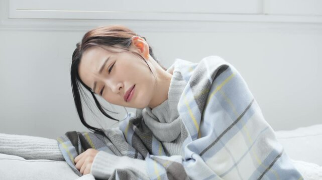 風邪、かぜ、発熱、冬、女性、日本人、せき、インフルエンザ、寒い、寒暖差、咳き込む、冷え性、室内、リビングルーム、体調不良、疲れ、疲労、ダウン、ストール、防寒、エアコン、暖房、アレルギー、交感神経、自律神経、ストレス、困る、悩む、悩み、ブランケット、毛布、対策、休む、つらい、落ち込む、がっかり、頭痛、コロナ、ライノウイルス、RSウイルス、寒気、悪寒、溶連菌、冬風邪、倦怠感、寝込む、病気、休養、不安、