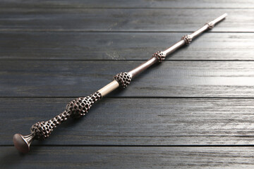 One old magic wand on wooden table, closeup