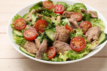 Delicious fresh tuna salad on white wooden table, closeup