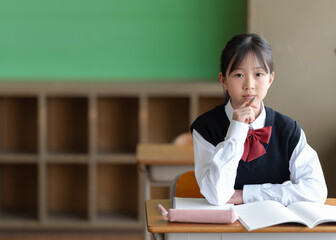 教室でペンを持つカメラ目線の女子中学生