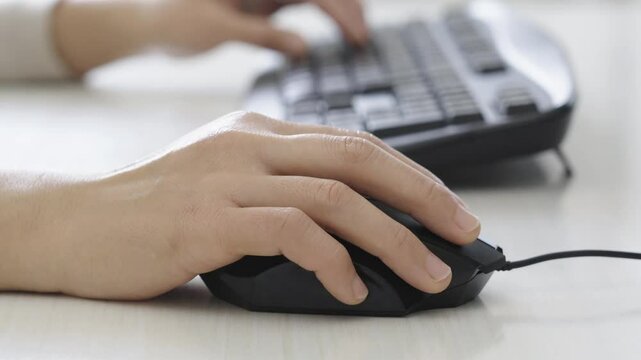 Woman hand clicking computer mouse on office table.