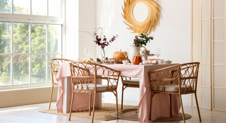 Autumn table setting decorated for Thanksgiving Day with pumpkins and eucalyptus branches in light dining room