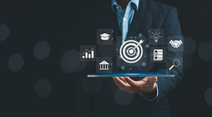 Goal and target concept, businessman showing dartboard and arrow on hand to set business goals, marketing solutions, strategy or data analysis to achieve best business results
