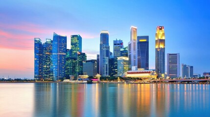 Naklejka premium Stunning Illuminated Cityscape with Skyscrapers Reflecting in the Water at Sunset