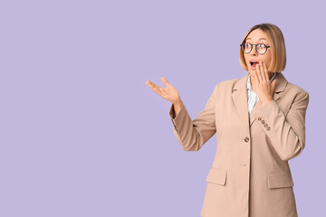 Shocked adult woman on lilac background