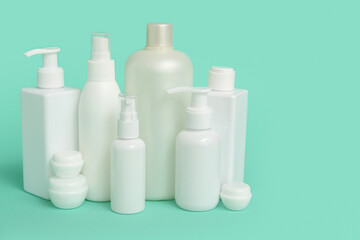 Different cosmetic products on green background