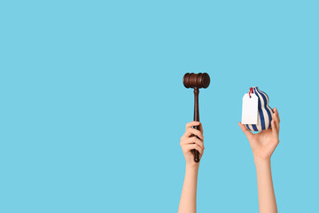 Woman holding auction gavel and antique vase on blue background