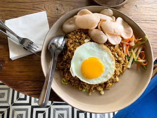 A plate of fried rice with half-cooked egg. This dish is a delicious Indonesian specialty