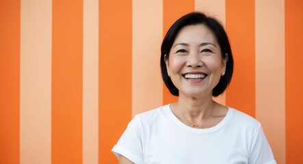 east asian mature woman orange background wearing plain white tshirt smiling happy portrait
