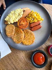 Mix Breakfast with beef, sausages, scrambled egg, mushrooms, tomato, corn on the plate