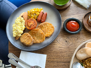 Mix Breakfast with beef, sausages, scrambled egg, mushrooms, tomato, corn on the plate