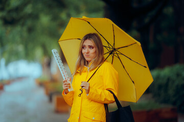 Woman Holding a Thermometer and an Umbrella Checking the Weather. Confused lady trying to see if...