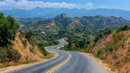 Fototapeta premium Winding Road Through Mountain Landscape Asphalt Green Hills Blue Sky