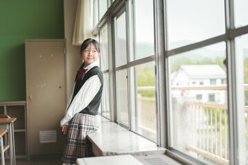 Fototapeta premium 教室で窓の外を見る日本人の女子中学生