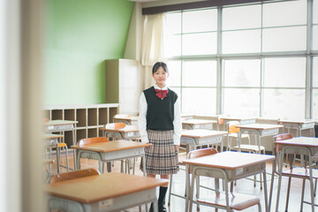 教室の中で立っている日本人の女子中学生のポートレート