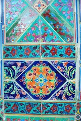 A traditional design of a beautiful tiles in the Buddhist temple, a symmetric colorful paining design of a flora. A symbol of ancient culture, delicate design, creative thinking, and artistic works