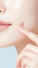 Naklejka premium A close-up of a woman's face, highlighting her finger gently touching her cheek, emphasizing smooth skin and skincare.