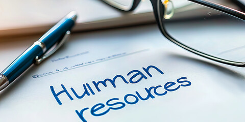 The word "human resources" is written on a white piece of paper using a pen, with a pair of glasses nearby, generative AI